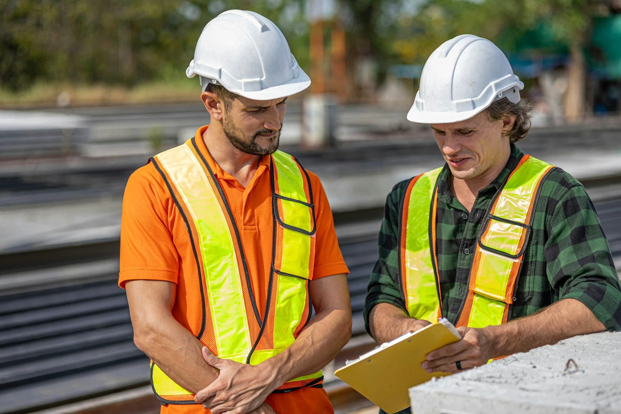 Two professionals reviewing documents on a construction site